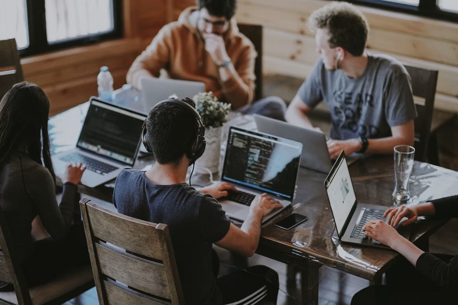 Team working together on laptops around a shared desk